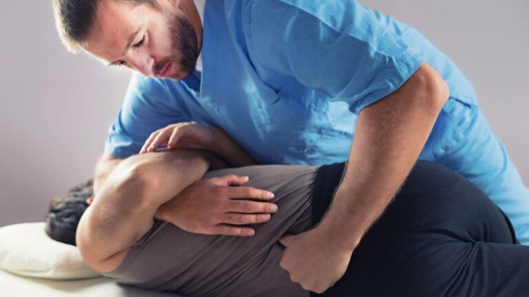 A healthcare professional is performing a treatment on a patient lying on their side.